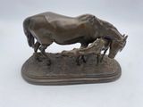bronze statue of a horse and her foal on a wooden base