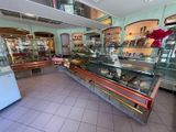 an image of a bakery with a glass case full of pastries