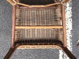 a wicker chair that is sitting on the street
