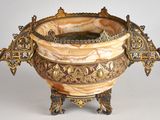 un grand vase décoré posé sur un socle