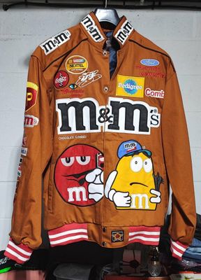 a brown jacket with m & m ' s on it hanging on a wall