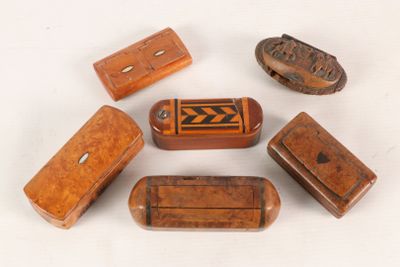 several small wooden objects are arranged in a circle on a white surface