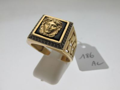 un gros plan d'une bague en or sur laquelle est gravé un visage