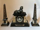 a statue of a lion and a clock on a table