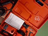 an orange box with a cordless drill and a charger in it