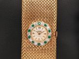 une montre-bracelet en or 18 carats sertie d'émeraudes et de diamants