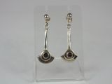 a pair of silver earrings with garnets on them on a clear surface