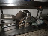 many pans and pans sitting on a shelf in the kitchen
