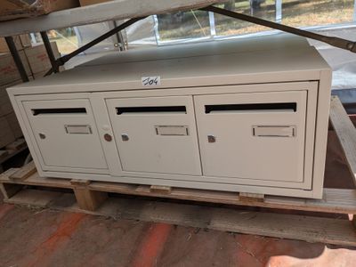 une boîte blanche posée sur une palette dans un entrepôt