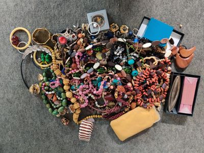 un tas de bijoux par terre, à côté d'un sac à main