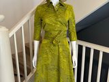 mannequin vêtu d'une robe verte et d'un chapeau, posé sur un escalier