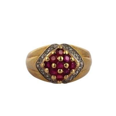 a close up of a gold ring with a ruby and diamond center