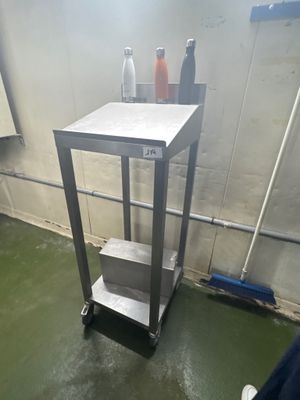 une petite table sur laquelle se trouve une bouteille, dans une pièce