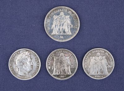 quatre pièces d'argent de tailles et de formes différentes sur un fond bleu