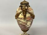 an image of a vase with a statue on top of it