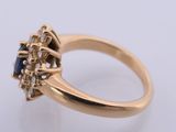 a close up of a gold ring with a sapphire and diamonds