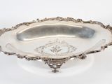 an antique silver plate with ornate design on the rim