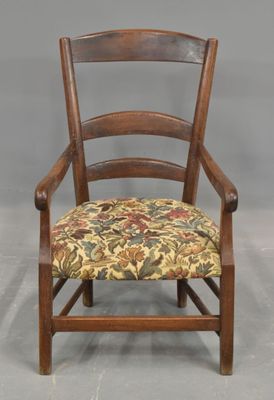 une image représentant une chaise en bois dont l'assise est recouverte d'un tissu à motifs floraux