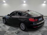 the back of a black bmw car is parked on a checkered tile floor