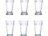 six glasses of different sizes are lined up on a white surface