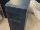 a black computer tower sitting on top of a table next to a mirror