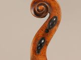 an antique violin with a wooden back and a scroll
