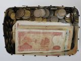 une boîte remplie d'argent et de pièces posée sur la table