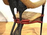 a wicker chair with a woven seat on a wooden floor