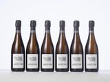 six bottles of wine lined up in a row on a table