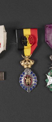 three medals are displayed on a black surface with a ribbon