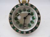 a close up of a clock with green and white decorations on it
