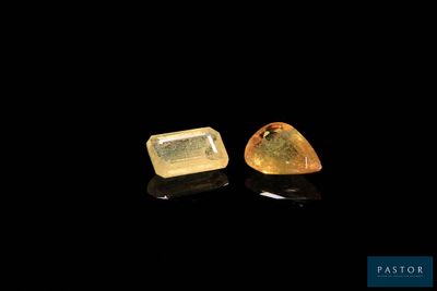 a pair of yellow sapphires on a black surface
