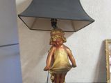 a lamp that has a little girl on it on a table