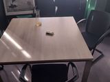 a table and chairs in a room with a picture on the wall