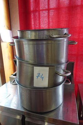 une grande casserole en métal posée sur une table en métal