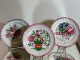 four plates with flowers and a bird on them