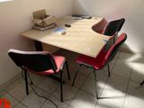 a table with two chairs and a laptop on it