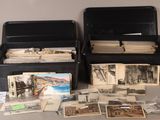 deux boîtes noires remplies de vieilles photos posées sur une table