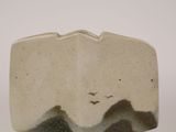 a picture of a white and brown vase with mountains in the background