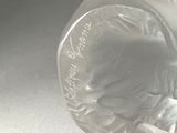 a glass vase with a design on it on a table
