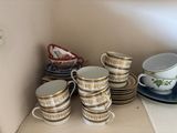 many cups and saucers sitting on a shelf
