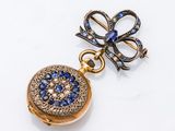 une image représentant une boucle d'oreille en or ornée de pierres bleues et blanches