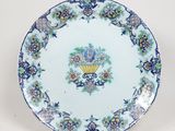 une assiette bleue et blanche ornée de fleurs et d'un éventail