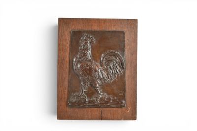 une plaque en bois représentant un coq sur un mur blanc