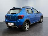 the rear end of a blue dacia parked in a showroom
