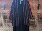 a black dress and jacket hanging on a wall in a room