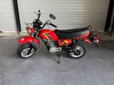 a red motorcycle parked in a garage next to a garage door