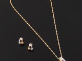 a gold necklace and earring set with a white and black stone