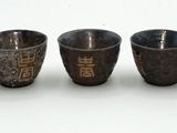four small cups are lined up in a row on a white surface