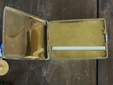 une petite boîte en métal contenant une médaille d'or